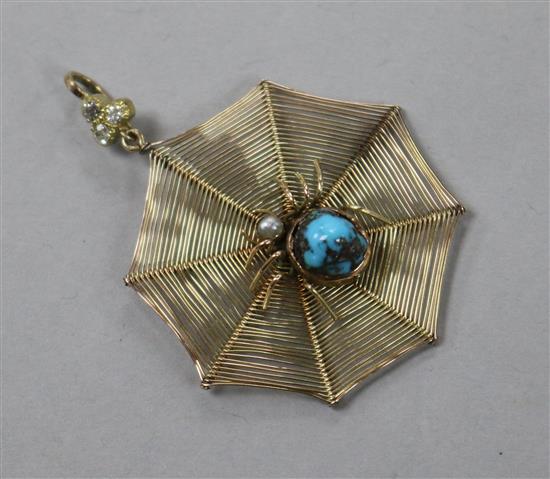 An early 20th century yellow metal spiders web pendant with gem set spider and diamond set bale, 30mm.